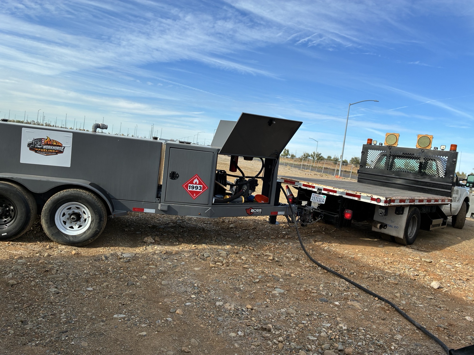 Workhorse Fueling trailer and flatbed truck with a fuel hose at the jobsite